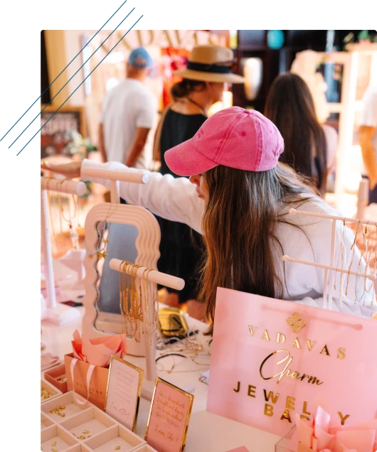 Attendee browsing a jewelry stand at an event marketplace