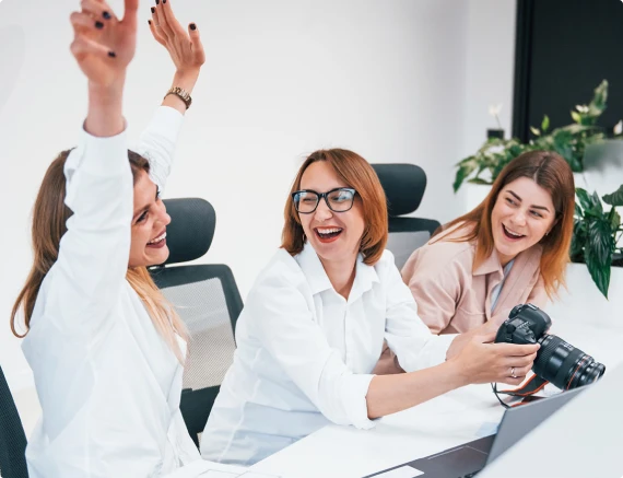 Creative team celebrating while reviewing photos