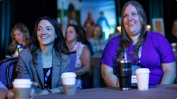 Attendees smiling during a conference session