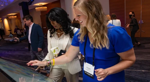 Attendees interacting with a touchscreen display at an event