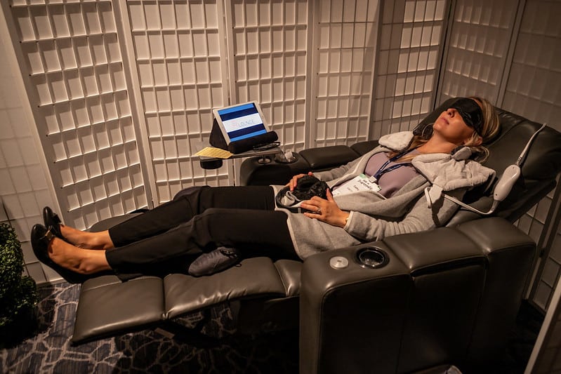 A woman reclines in a "mental health pod" at work