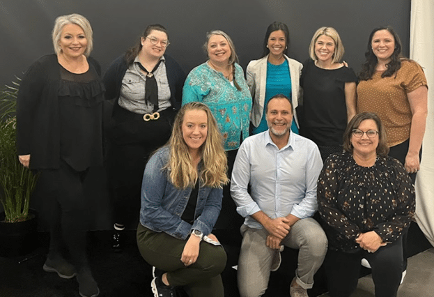 Group photo of nine M&IW employees at IMEX America 2023