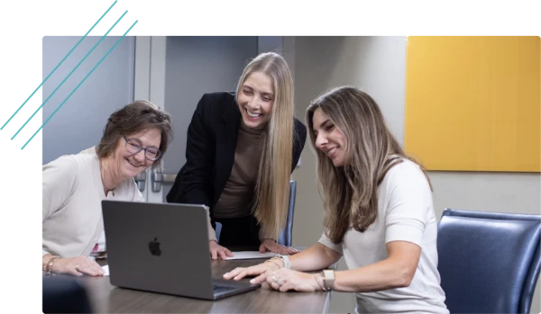 Three creative team members working on a laptop