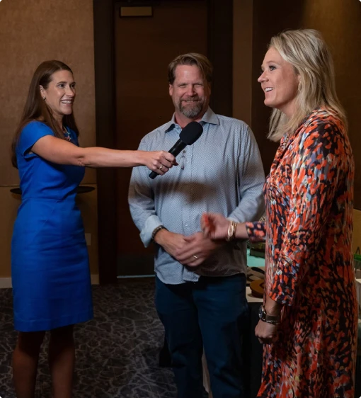 Presenter interviewing attendees with a microphone at an event