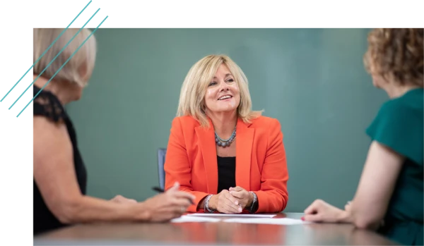 Woman presenting to colleagues at a meeting table