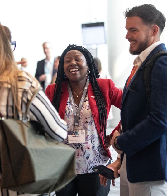 Event attendees laughing together during a networking break at a conference