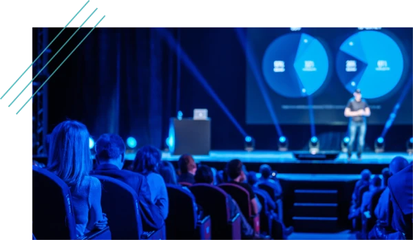 Speaker presenting on stage at a sales meeting