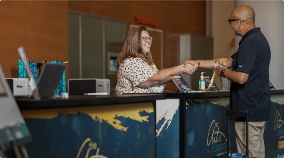 Hotel front desk staff greeting an attendee