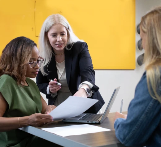 Consultants reviewing documents together at a meeting table