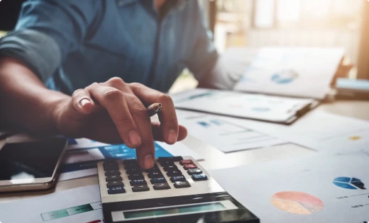 Analyst working through financial reports with a calculator